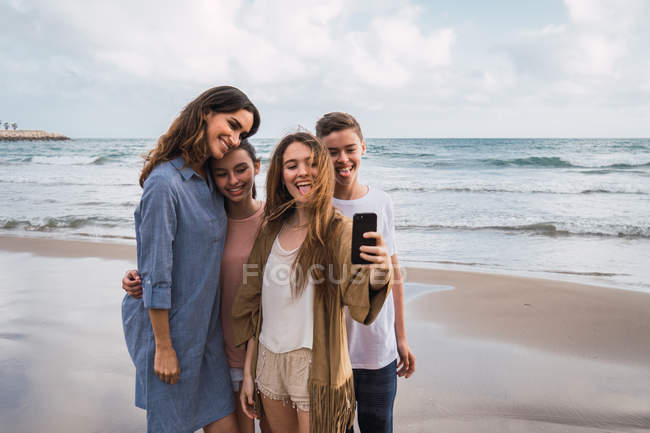 Felice donna e adolescenti prendendo selfie sulla spiaggia — Foto stock