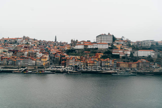 Canale e città vecchia con tetti arancioni in nuvoloso, Oporto, Portogallo — Foto stock