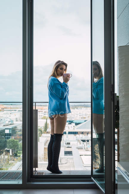 Chillen Mädchen beim Kaffee auf dem Balkon und Blick in die Kamera — Stockfoto