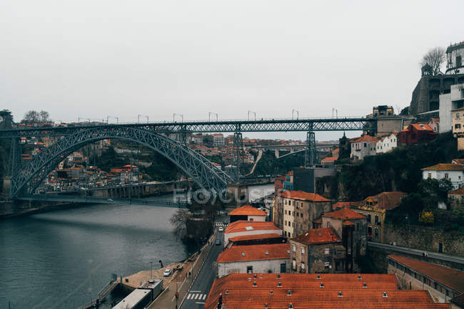 Bridge over channel and old city with orange roofs in overcast, Porto, Portugal — Stock Photo
