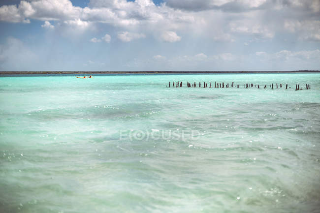 Filas de pilares en mar Caribe turquesa en día nublado, México - foto de stock