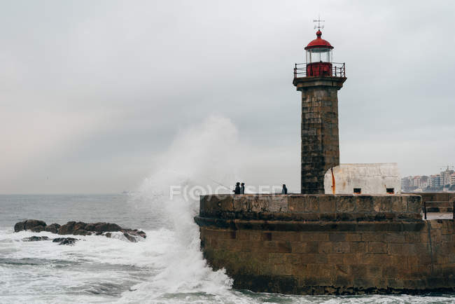 Tour de balise sur jetée à l'océan ondulé, Porto, Portugal — Photo de stock