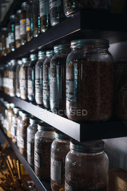 Gros plan de l'étagère avec assortiment d'épices dans des pots — Photo de stock