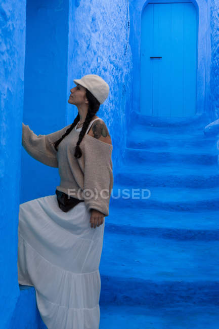 Frau berührt blau gefärbte Wand auf Straße in Marokko — Stockfoto