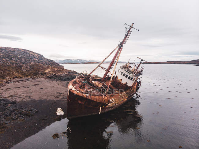 Deserted sail ship lying near rocky shore of North Iceland — Stock Photo