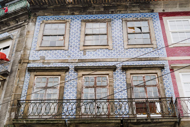 Viejas ventanas gruesas en edificio de azulejos azules en la ciudad vieja, Oporto, Portugal - foto de stock