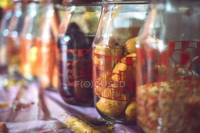 Close-up shot of glass jars full of various fruits and spices sold on market in San Cristobal de las Casas in Chiapas, Mexico — Stock Photo