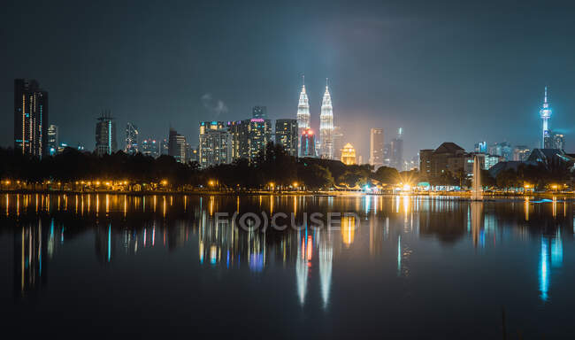 Vista sulla bellissima metropoli illuminata che si riflette nell'acqua di notte. — Foto stock
