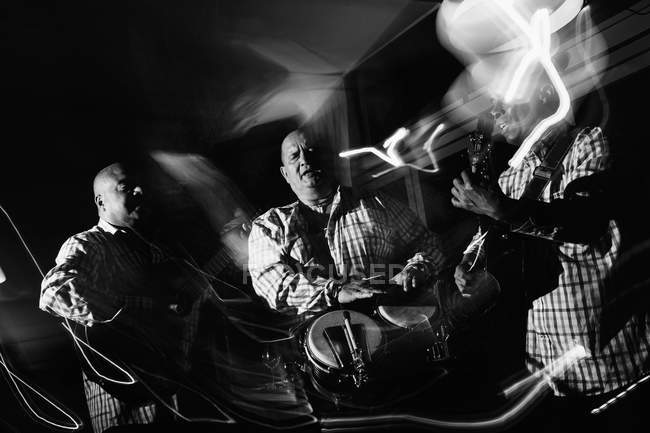 Trio musical cubano atuando em boate, tiro preto e branco com longa exposição — Fotografia de Stock