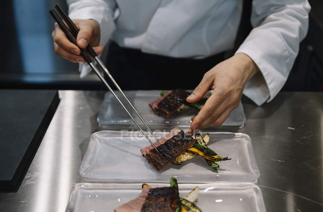 Chef preparing dishes with chopsticks in restaurant — Stock Photo