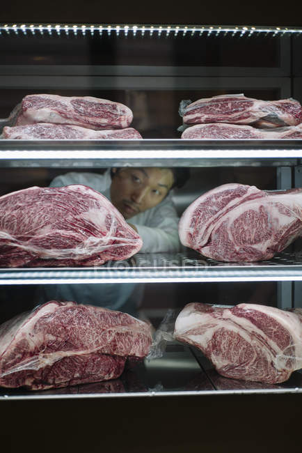 Japonés cocinero colocado wagyu carne de res en el estante en nevera - foto de stock