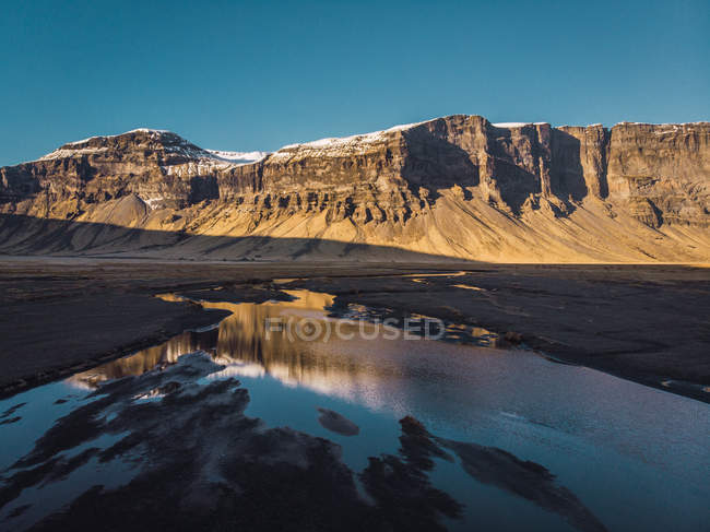 Schneebedeckter felsiger Berg und Tal mit Fluss, Island — Stockfoto