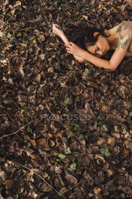 Beautiful nude woman lying on ground — Stock Photo