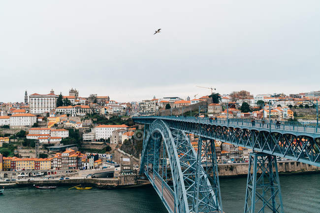 Мост через канал и старый город с оранжевыми крышами в пасмурном виде, Порту, Португалия — стоковое фото