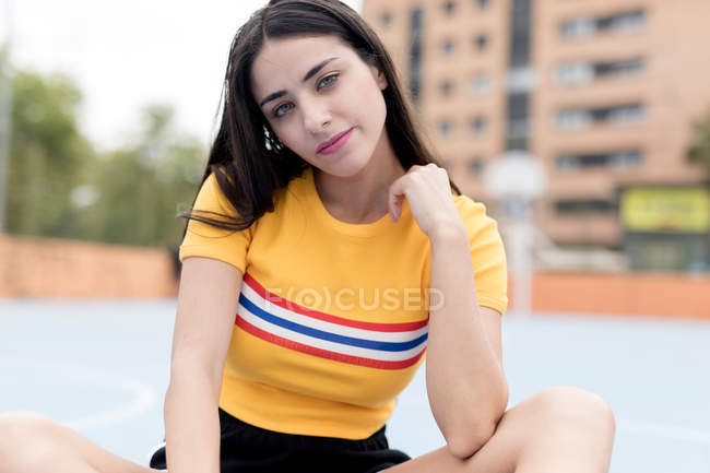 Portrait of Young woman sitting on sports ground — Stock Photo
