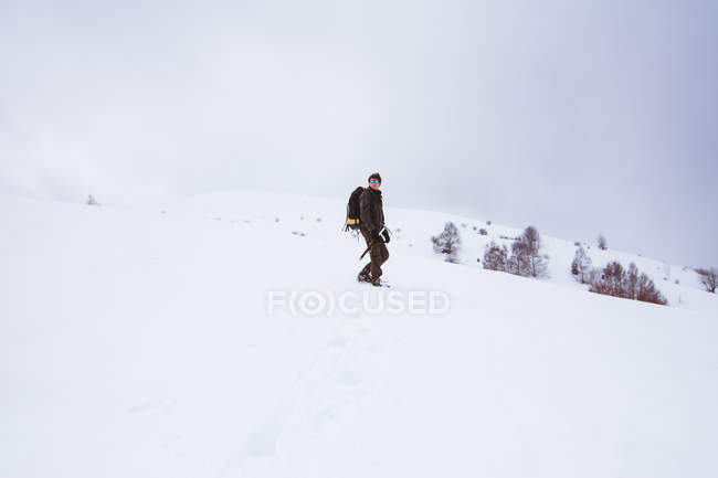 Турист з рюкзаком сходження на засніжену гору — стокове фото