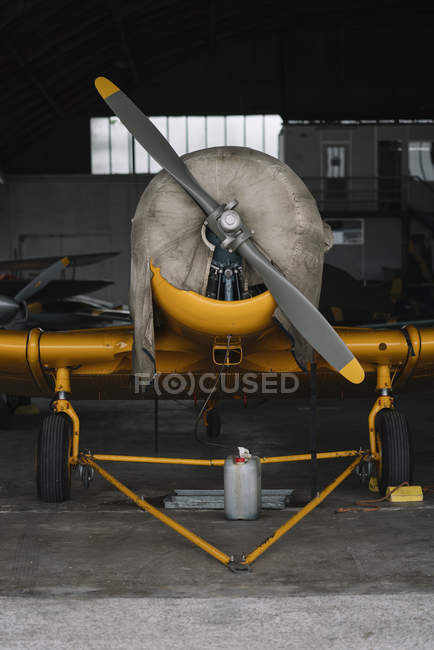Close-up of airscrew on nose cone of small plane in hangar — Stock Photo