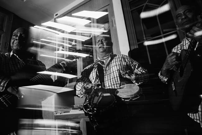 Trio musical cubain se produisant dans une boîte de nuit, plan noir et blanc avec une longue exposition — Photo de stock