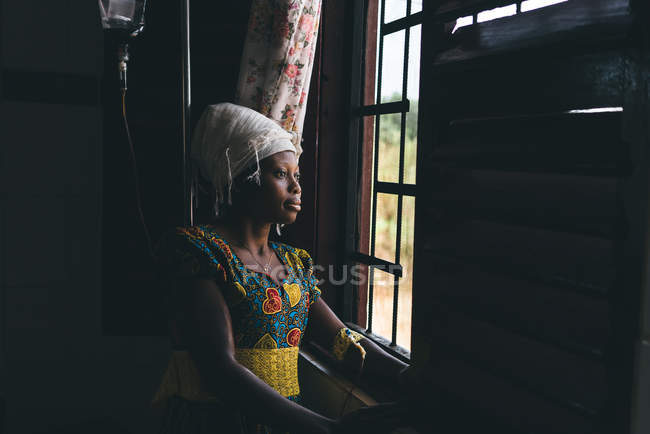 CAMARÕES - ÁFRICA - 5 de abril de 2018: Mulher muito africana olhando pela janela — Fotografia de Stock