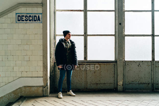 Uomo adulto in piedi alla finestra vicino alle scale in ingresso — Foto stock