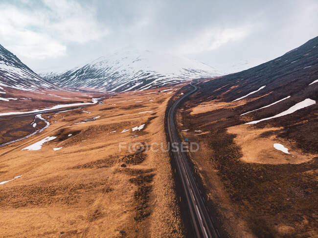 Estrada estreita passando por um belo terreno montanhoso no norte da Islândia — Fotografia de Stock