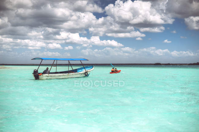 Лодки в бирюзовом Карибском море с облачным небом, Мексика — стоковое фото