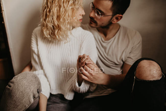 Jovem casal sentado no chão em casa juntos — Fotografia de Stock