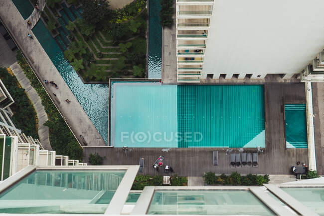 Vista superior de la piscina turquesa en edificios altos. - foto de stock