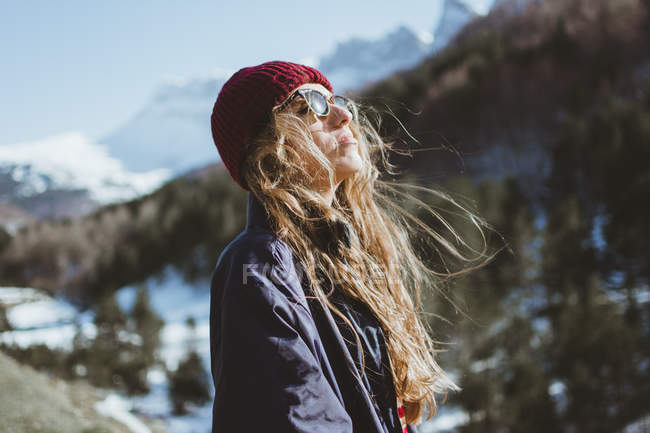 Femme profitant du soleil dans les montagnes en hiver — Photo de stock