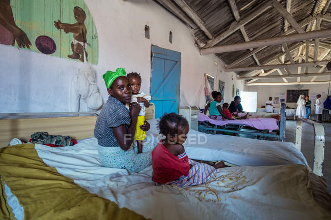 Angola - afrika - 5. april 2018 - afrikanerin mit kindern auf bett in klinik — Stockfoto