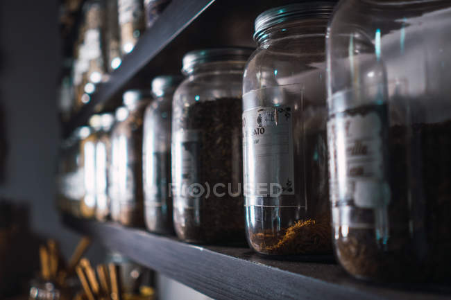 Gros plan de l'étagère avec assortiment d'épices dans des pots — Photo de stock