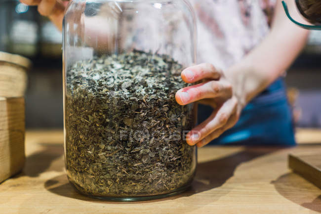 Close-up of female hands opening jar with spices — Stock Photo