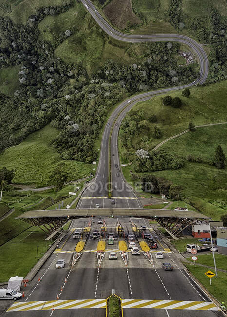 Toll automobile road leading upwards to green nature and forest. — Stock Photo
