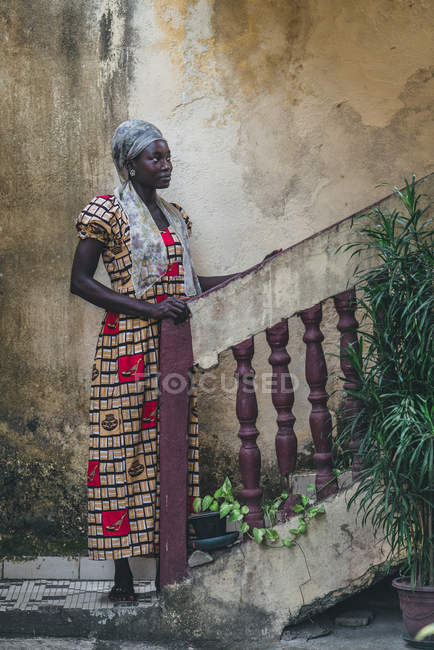 Kamerun - Afrika - 5. April 2018: Nachdenkliche junge ethnische Frau steht an der Treppe und schaut weg — Stockfoto