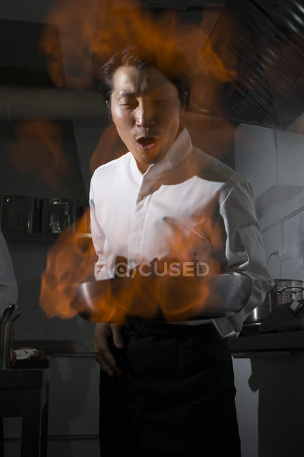 Cuoco eccitato facendo un flambe in cucina ristorante — Foto stock