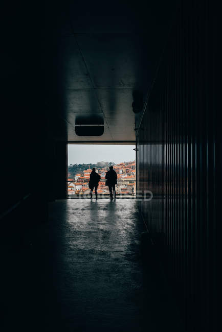 Dark hall and men standing at viewpoint of old town with orange roofs, Porto, Portugal — Stock Photo