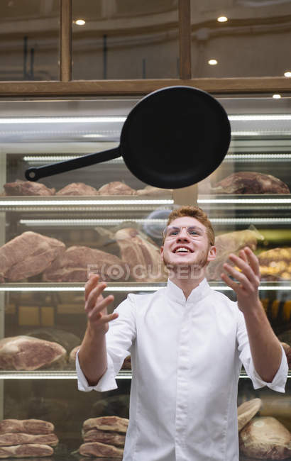 Chef cook throwing up frying pan in restaurant — Stock Photo