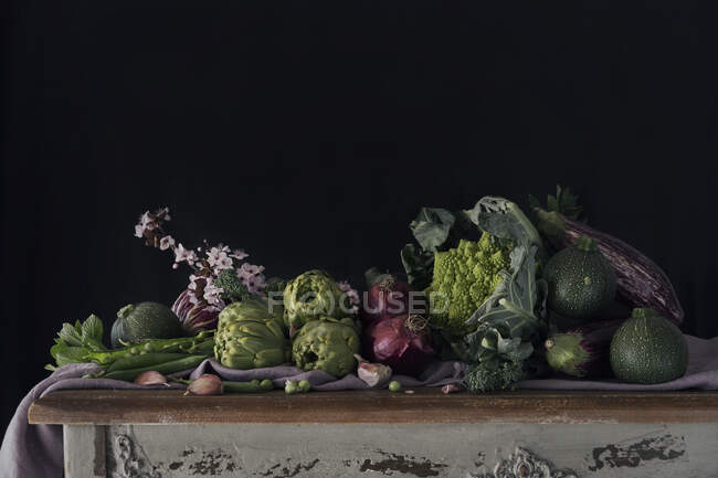Bella disposizione rustica di varie verdure verdi in assortimento sul tavolo con sfondo nero. — Foto stock