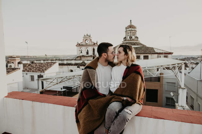 Пара обіймається з ковдрою на терасі в старому місті — стокове фото