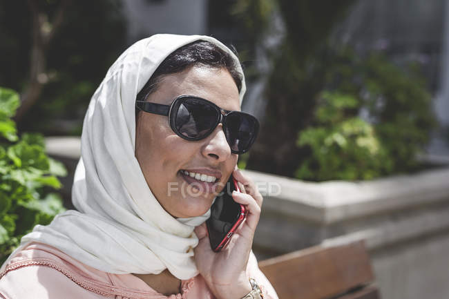 Primer plano de la mujer marroquí con hijab hablando por teléfono - foto de stock