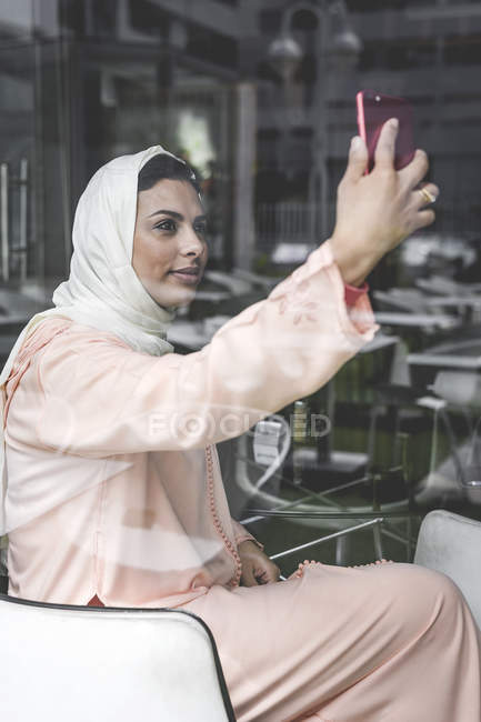 Elegant Moroccan woman with hijab and typical Arabic dress taking selfie — Stock Photo