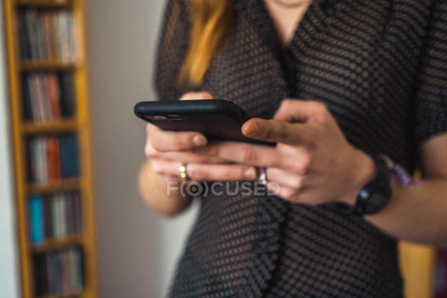 Close-up de mãos femininas usando telefone celular em casa — Fotografia de Stock