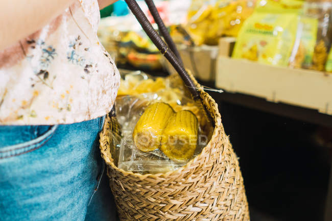Крупним планом людина тримає кошик з кукурудзою в супермаркеті — стокове фото
