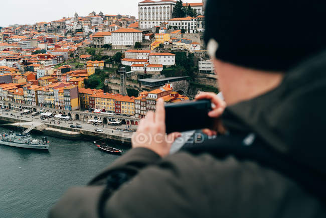 Touriste masculin prenant des photos de la vieille ville avec smartphone, Porto, Portugal — Photo de stock