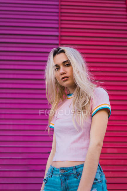 Blonde woman posing against purple wall — Stock Photo