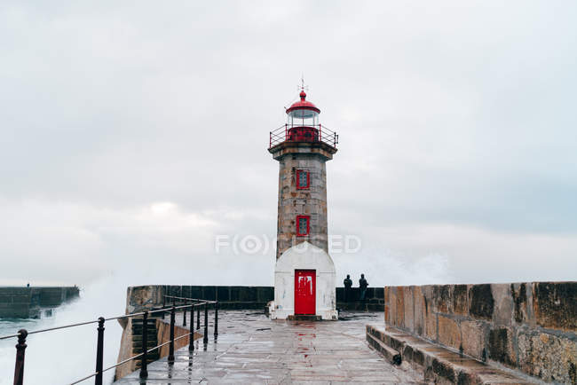 Beacon tower at wavy ocean in overcast, Porto, Portugal — Stock Photo