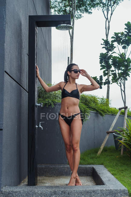 Bella donna in piedi alla moderna doccia piscina — Foto stock
