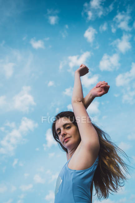 Портрет молодой женщины в синем купальнике, стоящей на фоне голубого неба — стоковое фото