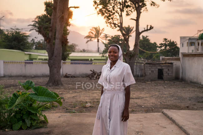 Angola - afrika - 5. April 2018 - lächelnde ethnische Krankenschwester, die an einem sonnigen Abend steht und in die Kamera blickt — Stockfoto