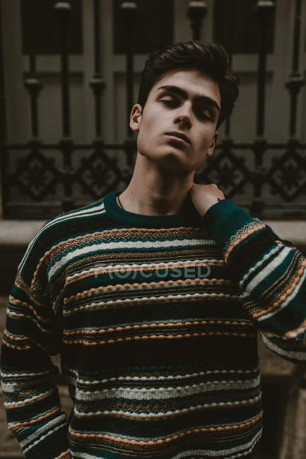 Молодой уверенный подросток в свитере стоит на улице с закрытыми глазами — стоковое фото